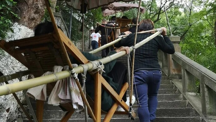 重量级游客雇3名轿夫抬轿下山，引发网友热议，旅游新潮流还是过度奢华？